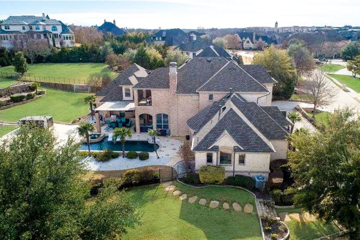 House plan exterior featuring a two-story brick home with multiple gables, a covered patio, and a swimming pool.