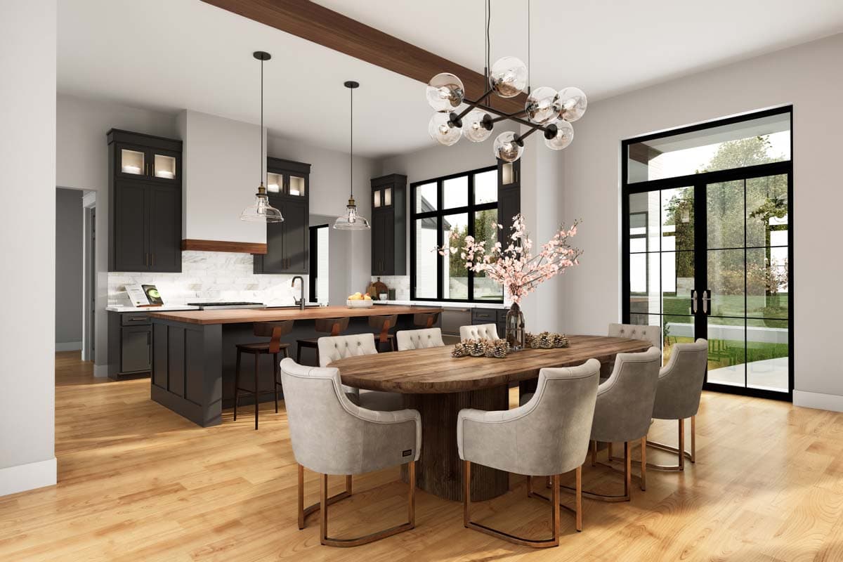 Open concept kitchen and dining area with dark cabinetry, large island, and dining table with upholstered chairs.