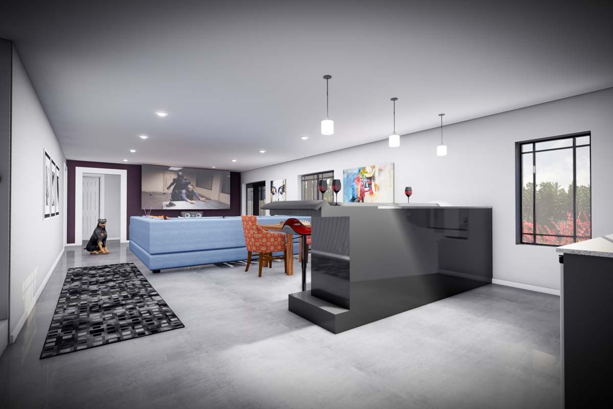 Open-plan living area with a large TV screen, blue sectional sofa, bar with pendant lights, and a window.