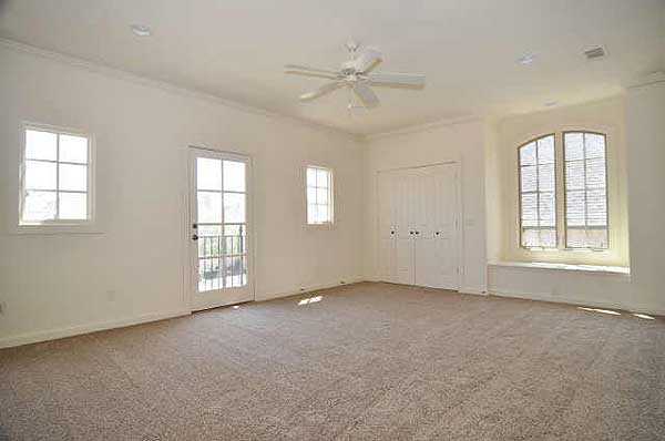 Interior view of a large room with a ceiling fan, French doors, multiple windows, and a large closet.