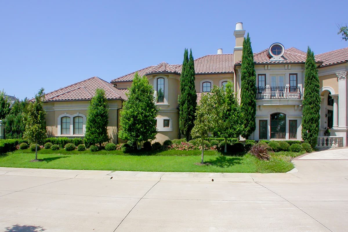 Mediterranean style house plan exterior with tile roof, arched windows, circular dormer, and wrought iron balcony.