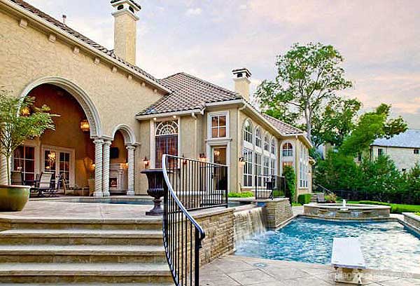 House plan exterior: stucco, tiled roof, arched loggia with columns, multi-story house with arched windows, and a swimming pool with waterfalls.