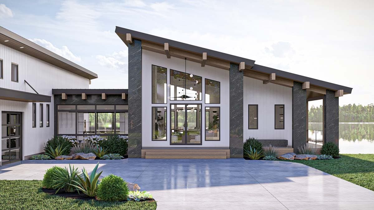 Modern house plan exterior with a steeply pitched roof, large glass entryway, and dark stone accents.