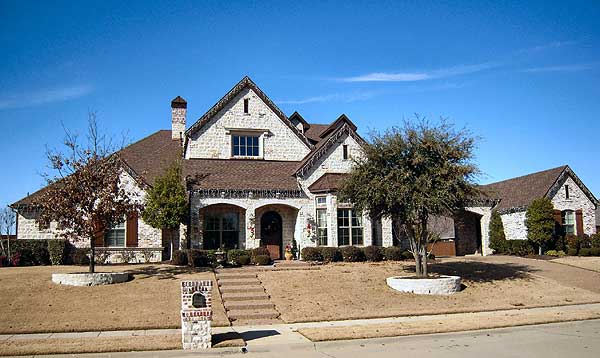 House plan exterior of a two-story home with stone facade, arched entry, gables, dormers, and attached garage.