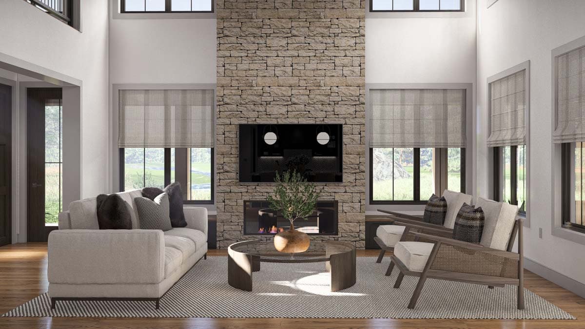Great room with vaulted ceiling, stone fireplace, seating area, and large windows.