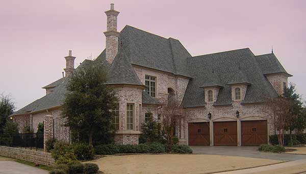 House plan exterior: two-story brick home with turret, multiple gables, and a three-car garage with arched doors.