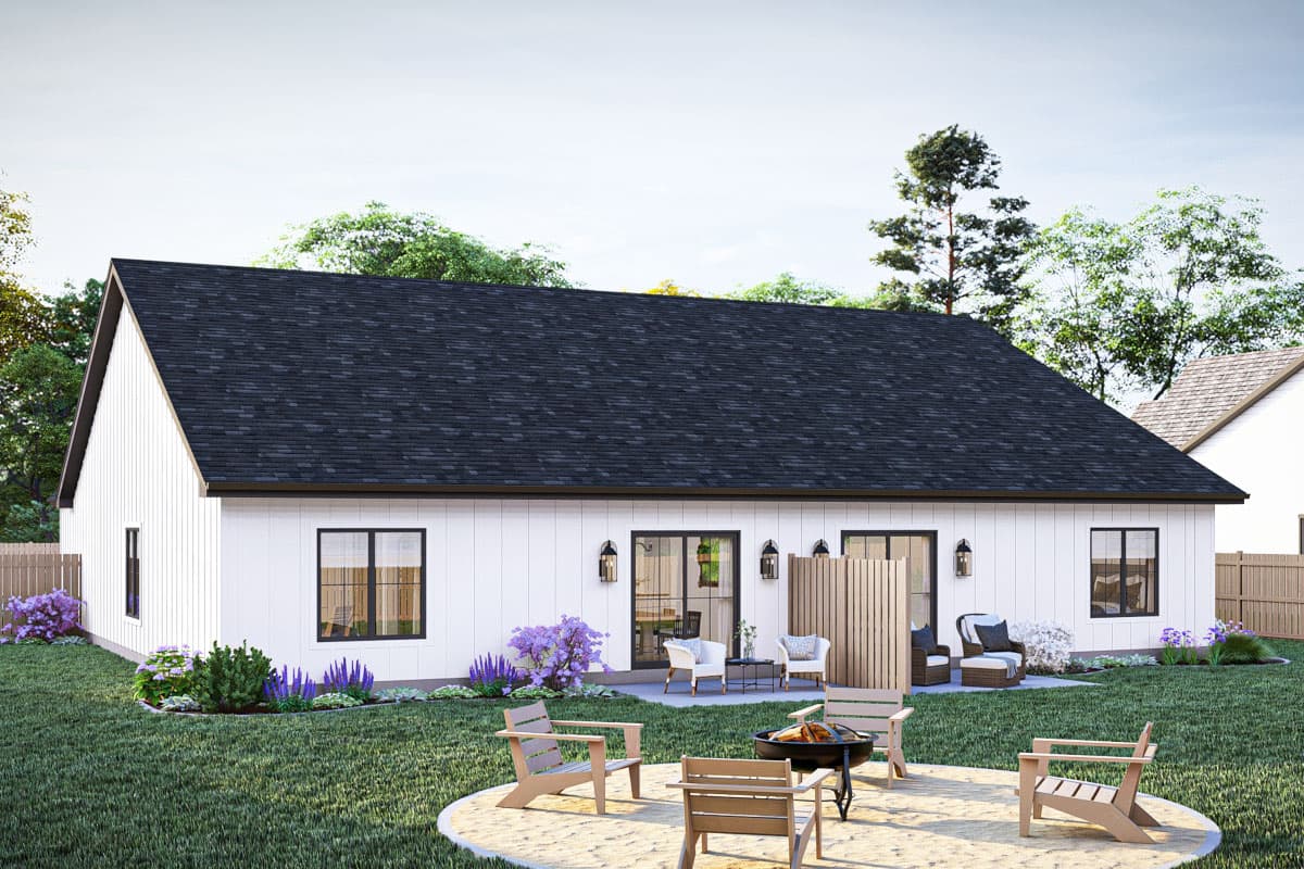 Modern farmhouse exterior of a one-story house with white vertical siding, dark gable roof, and three sliding glass doors.