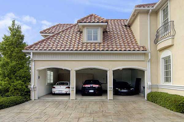 House plan exterior: Three-car garage with arched openings, red tile roof, and a dormer window.
