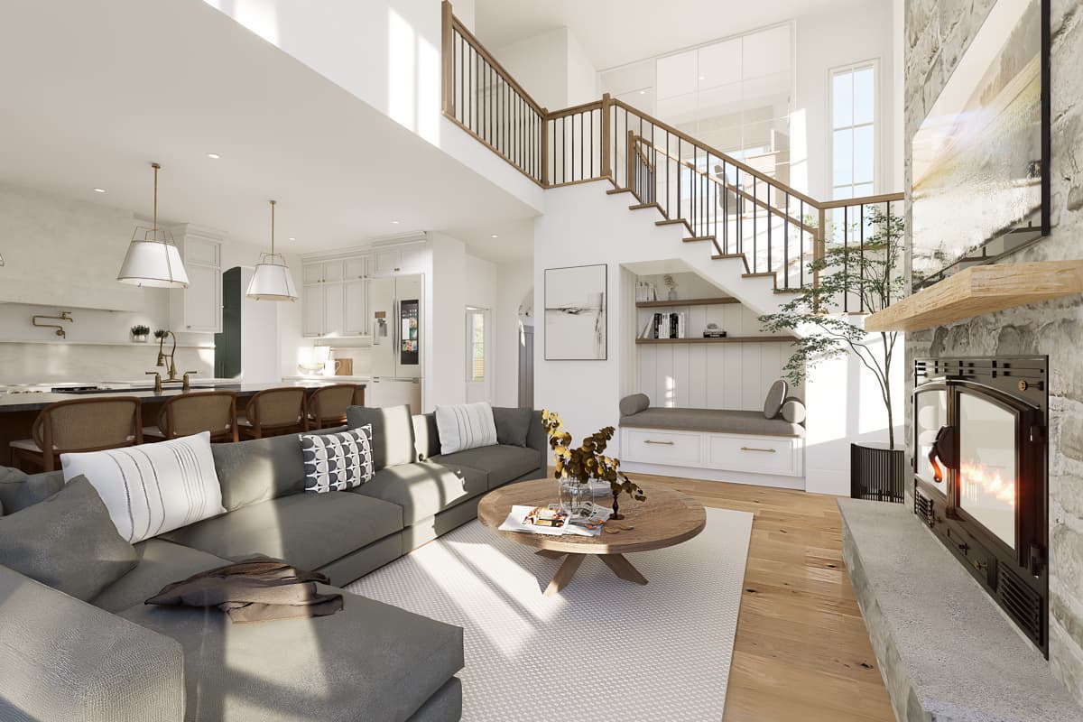 Spacious, modern living room with gray sectional sofa, fireplace, and staircase leading upstairs. A round coffee table sits on a rug.