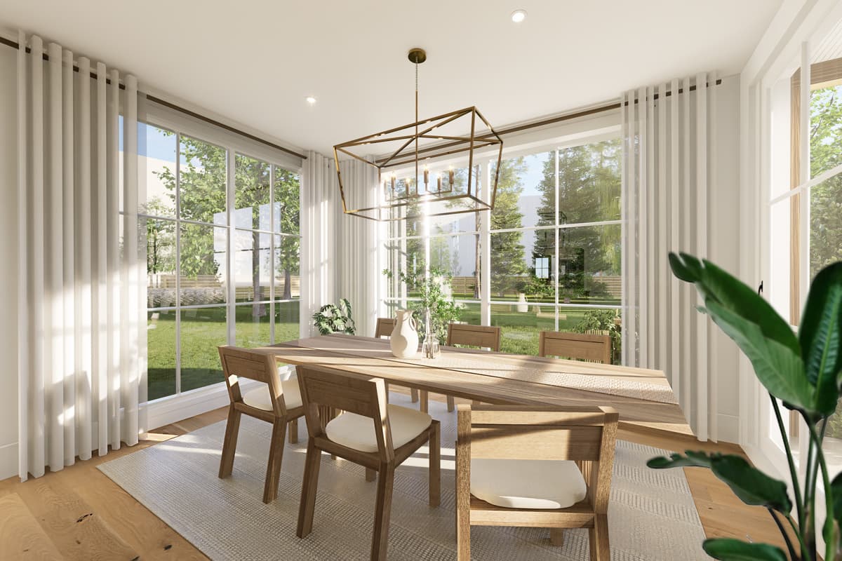 Bright, airy dining room with large windows overlooking a green yard. A long wooden table and chairs are centered under a geometric chandelier.