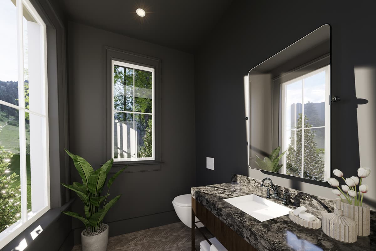 Modern bathroom with dark gray walls, a marble vanity, and a large mirror reflecting a window with a view of trees and a hillside.