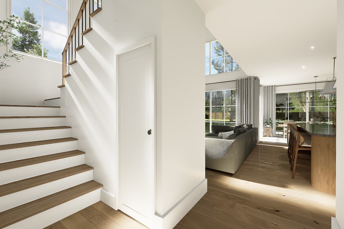 Bright, modern interior with a staircase, hardwood floors, and open living space. Large windows offer views of the outdoors, illuminating the home.