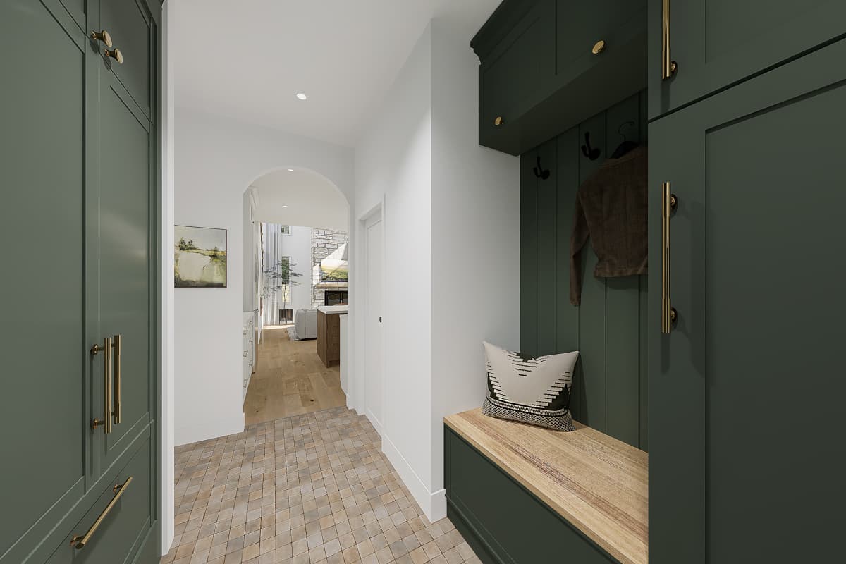 An entryway features a dark green mudroom with a coat rack, bench, and pillow. An archway leads to the living space with hardwood floors.