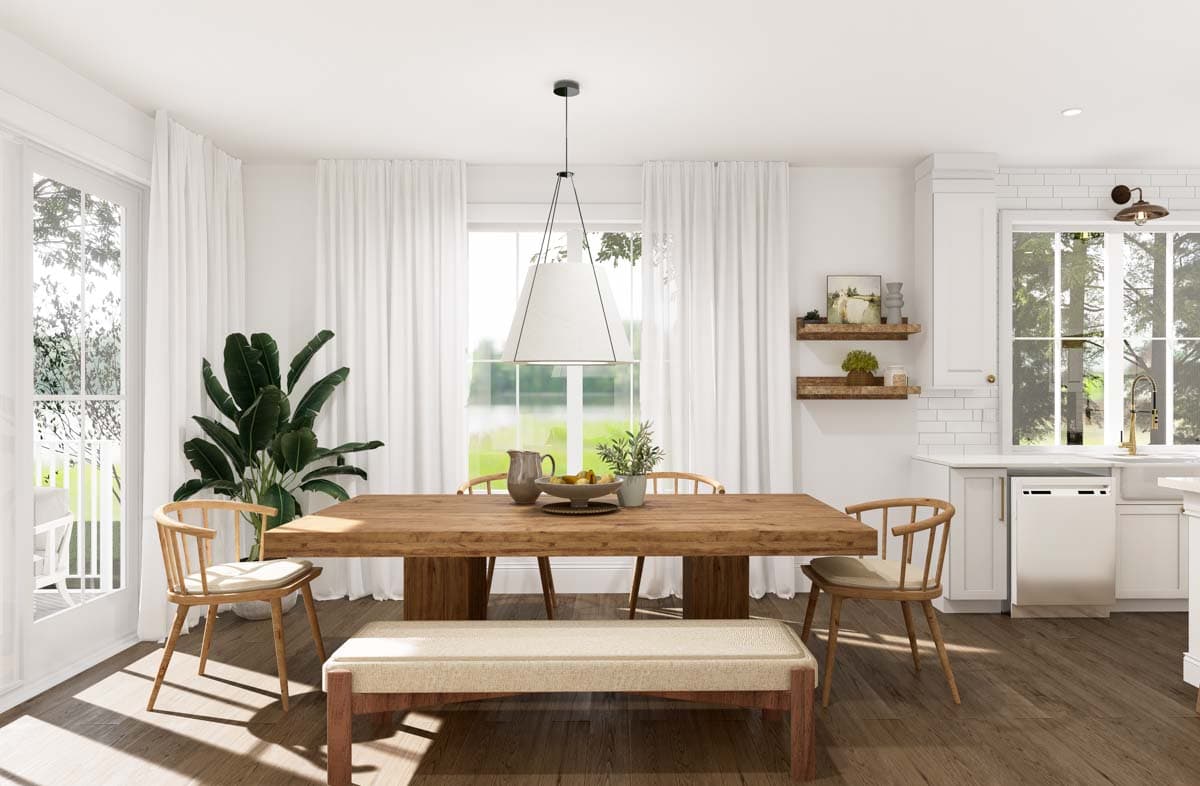 Dining area with large wooden table, chairs, bench, pendant light, and window overlooking greenery.