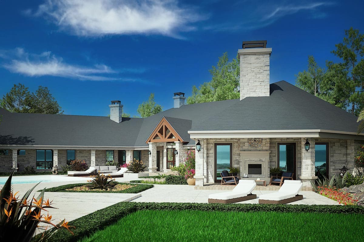 House plan exterior. Single-story ranch style with stone facade, multiple gables, prominent stone chimneys, and covered patios.