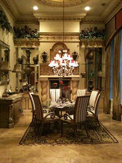 Dining room with ornate fireplace, chandelier, striped chairs, and traditional rug.
