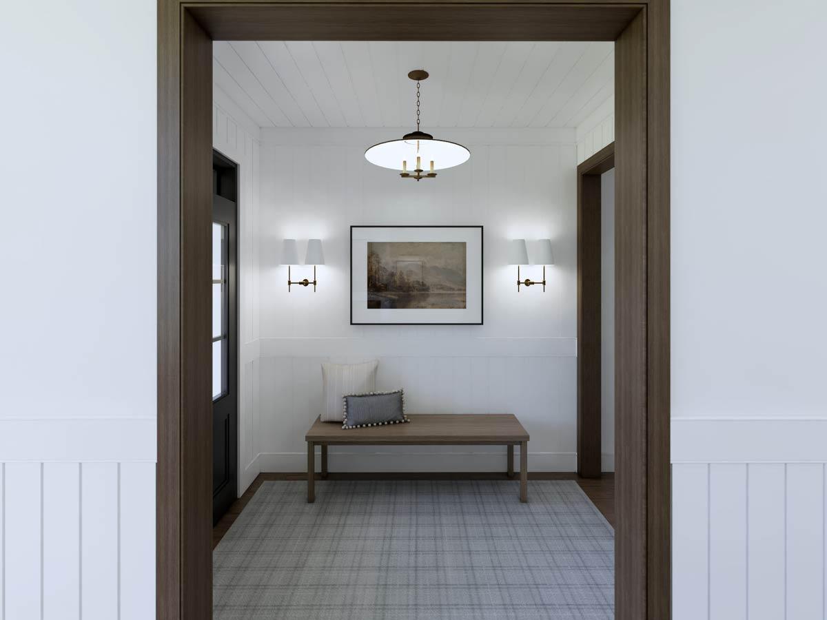 An interior shot reveals a hallway. A bench sits beneath a framed landscape, flanked by sconces. A patterned rug and a hanging light complete the scene.
