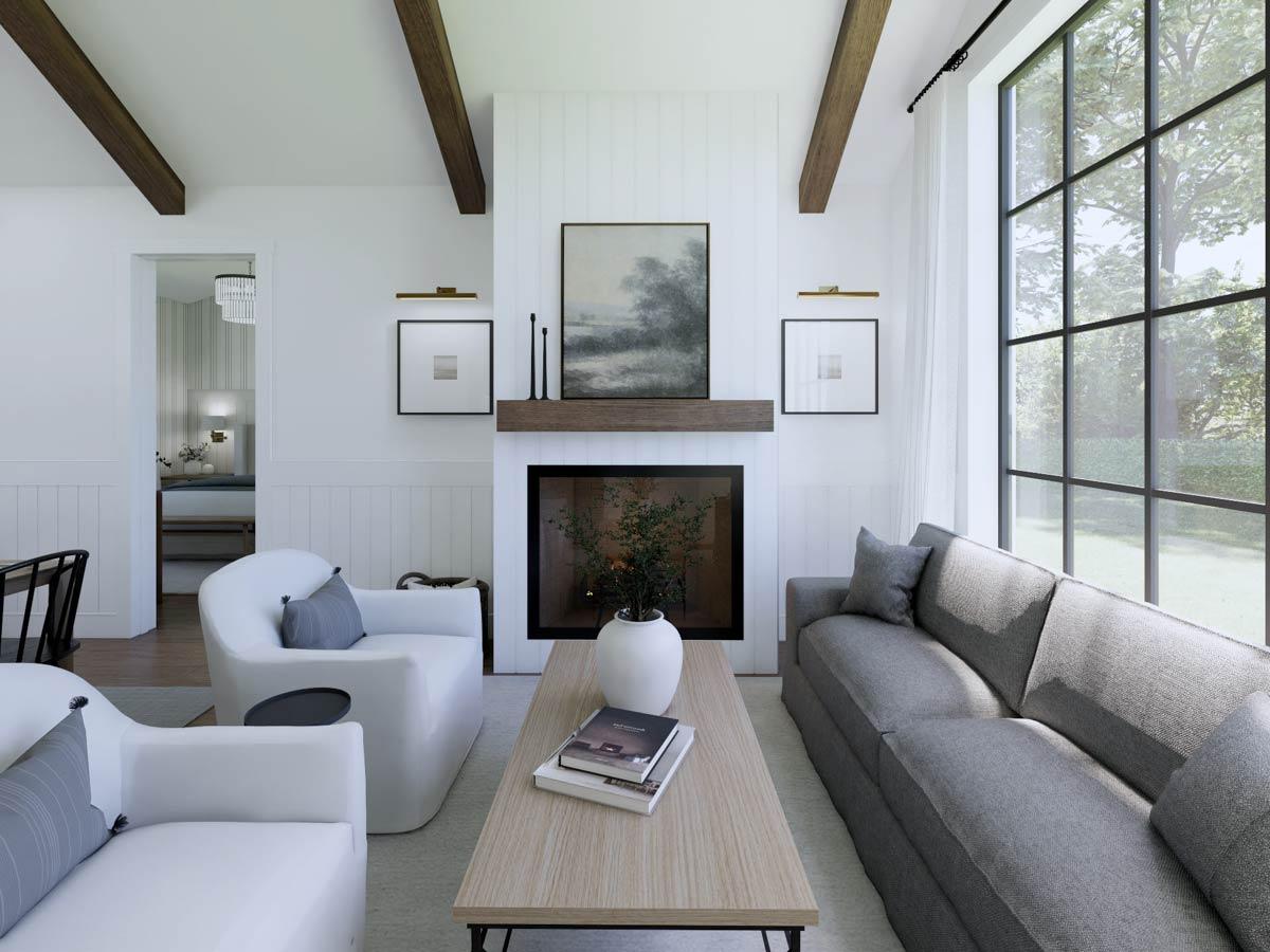Bright, modern living room with fireplace, two white armchairs, and gray sofa. Large window offers a view of a green outdoor space.