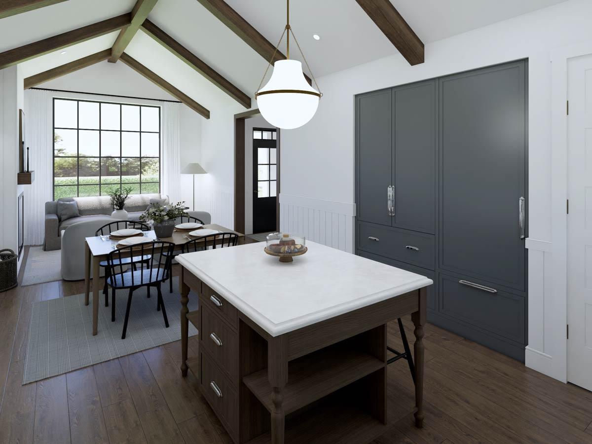 A bright kitchen and dining area featuring a wooden island with marble countertop, a dining table, and a large window looking outside.