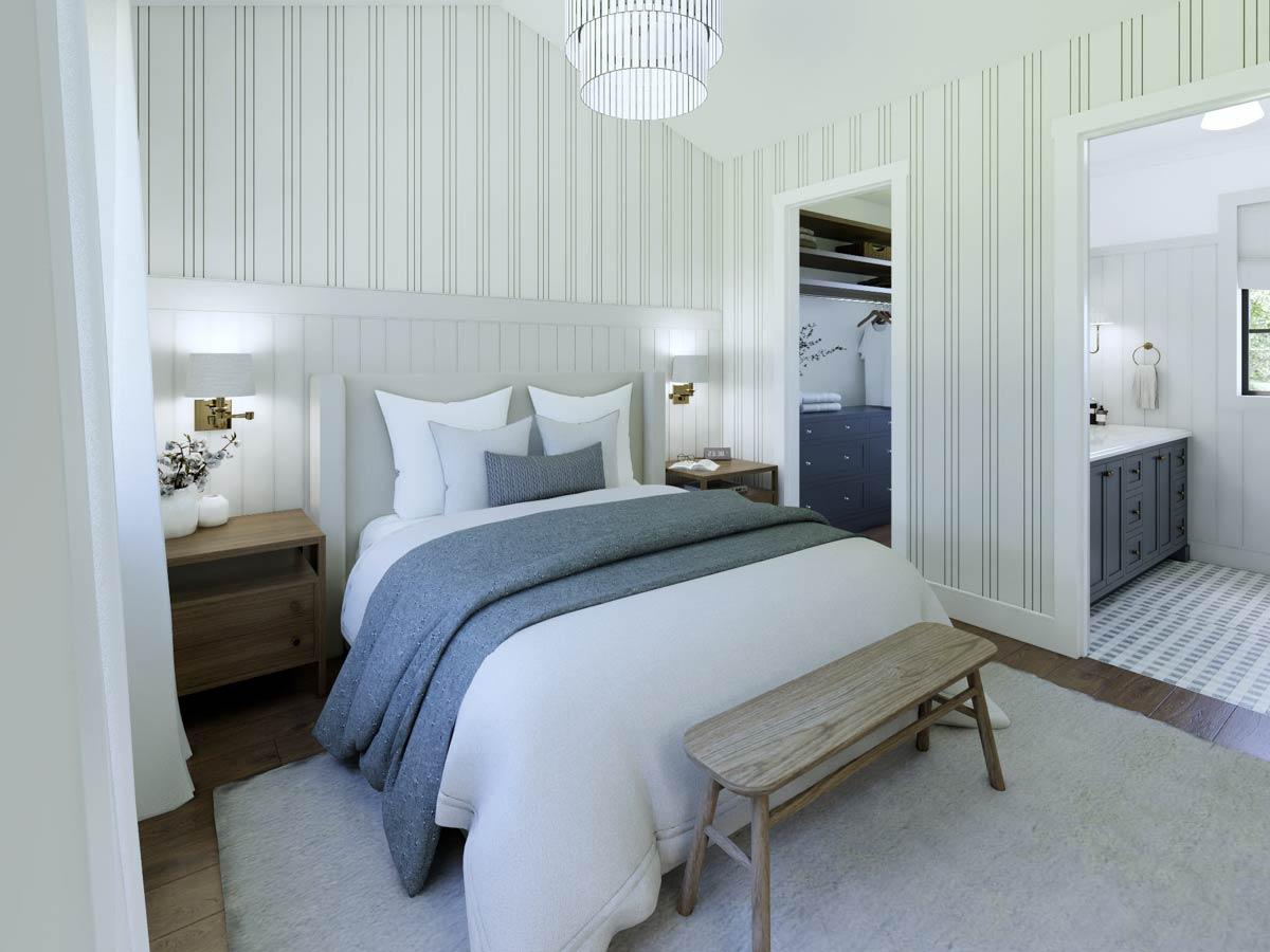 Cozy bedroom with a white bed, gray throw, and wooden bench. A doorway leads to a bathroom, and a second doorway shows a walk-in closet.