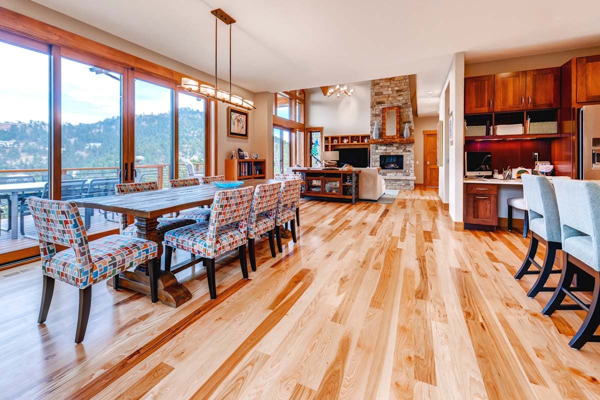 Open concept living area with dining room, great room fireplace, and kitchen workspace.