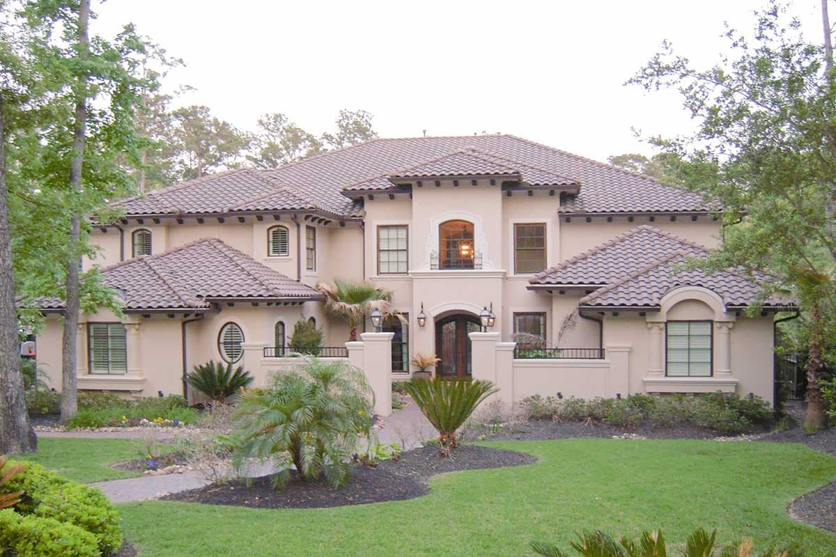 House plan exterior featuring a Mediterranean style, two stories, a tile roof, arched entryway, and decorative windows.