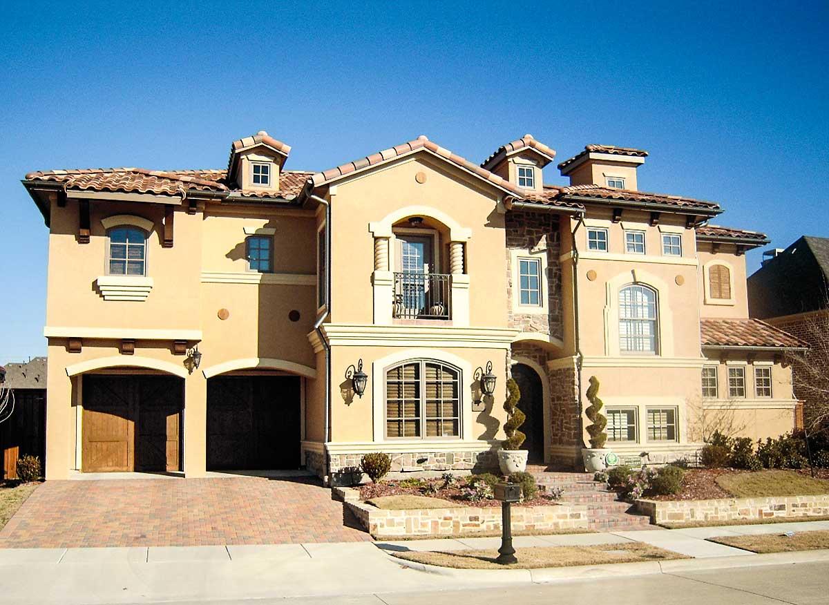 House plan exterior: Tuscan style, two stories, stucco facade, tile roof, dormers, arched windows, and double garage.