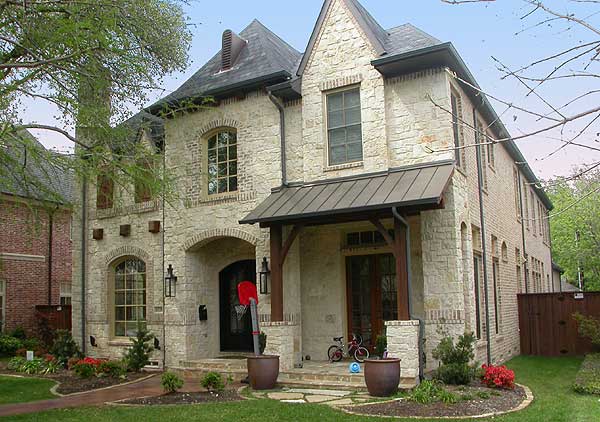 House plan exterior: Two-story stone and brick home with arched entry, metal awning over front door, and multiple gables.