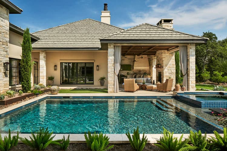 House plan exterior with covered outdoor living space featuring fireplace, seating, and pool with spa.