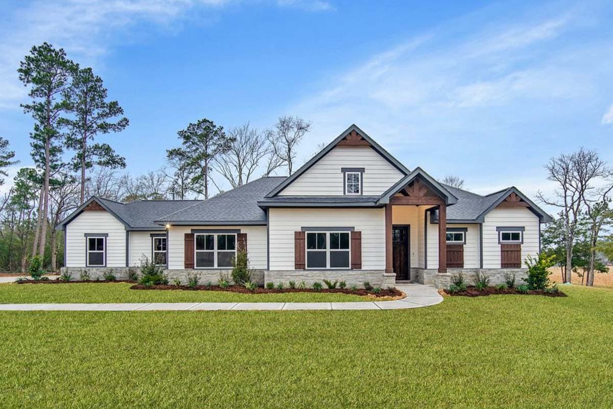 House plan exterior. Ranch style with a gabled roof, exposed wood beams, and decorative shutters. Features a covered entry and a stone facade.