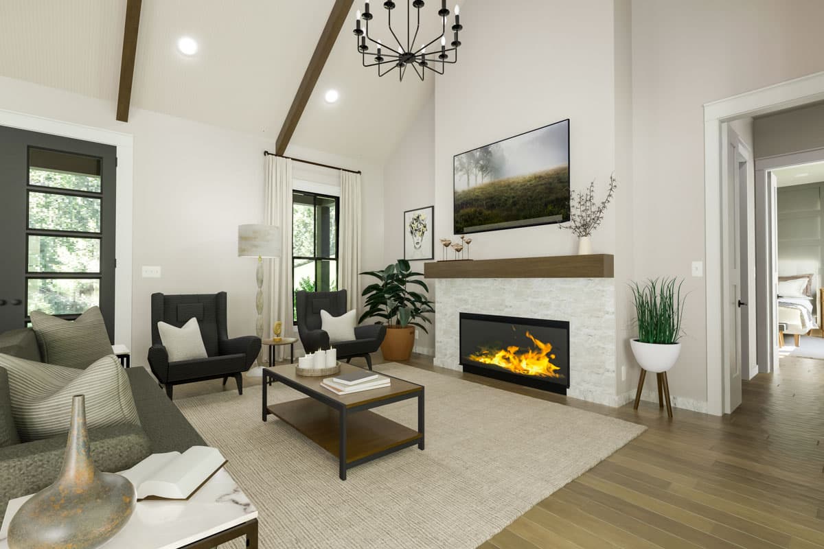 Living room with vaulted ceiling, wood beams, stone fireplace, and a large window overlooking trees.