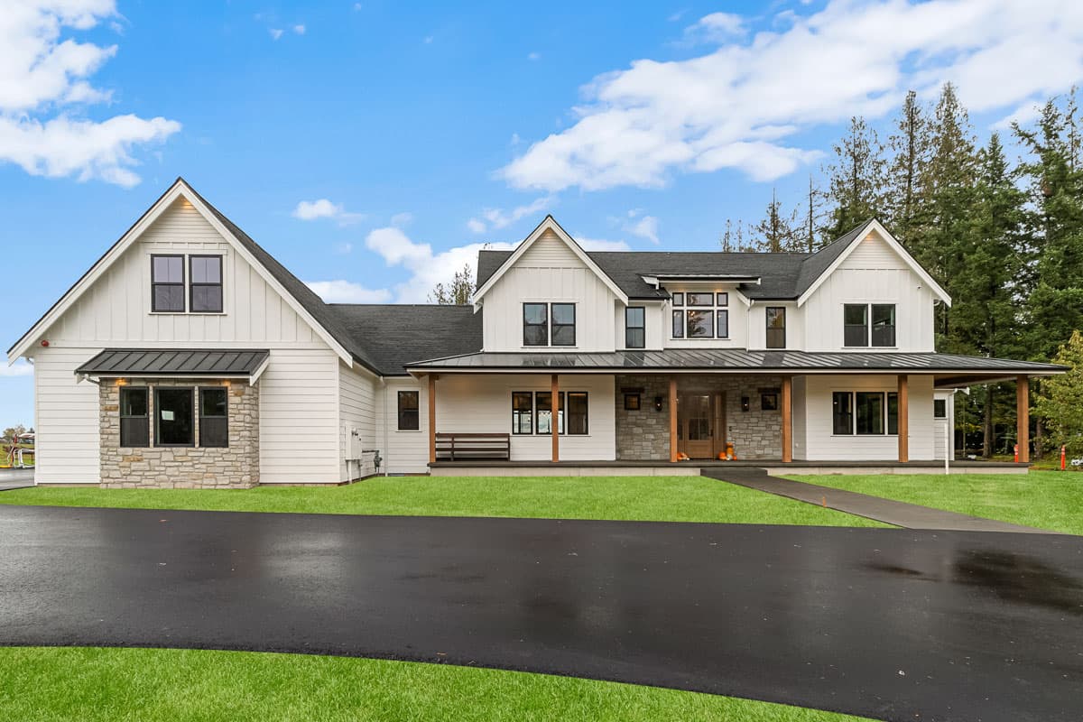 Modern Farmhouse house plan exterior with prominent gables, stone accents, and wide wrap-around porch.