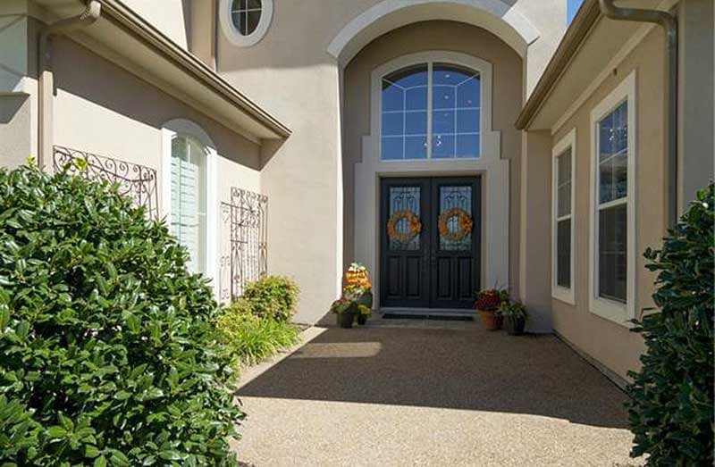 House plan exterior featuring double front doors, arched transomed window, and decorative window grilles.