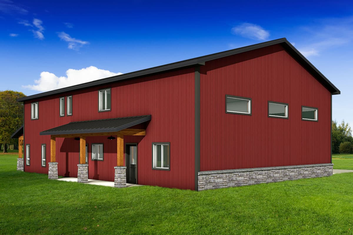 A two-story red building with a black roof and stone accents. The building has a porch with wooden beams and a green lawn in the foreground.