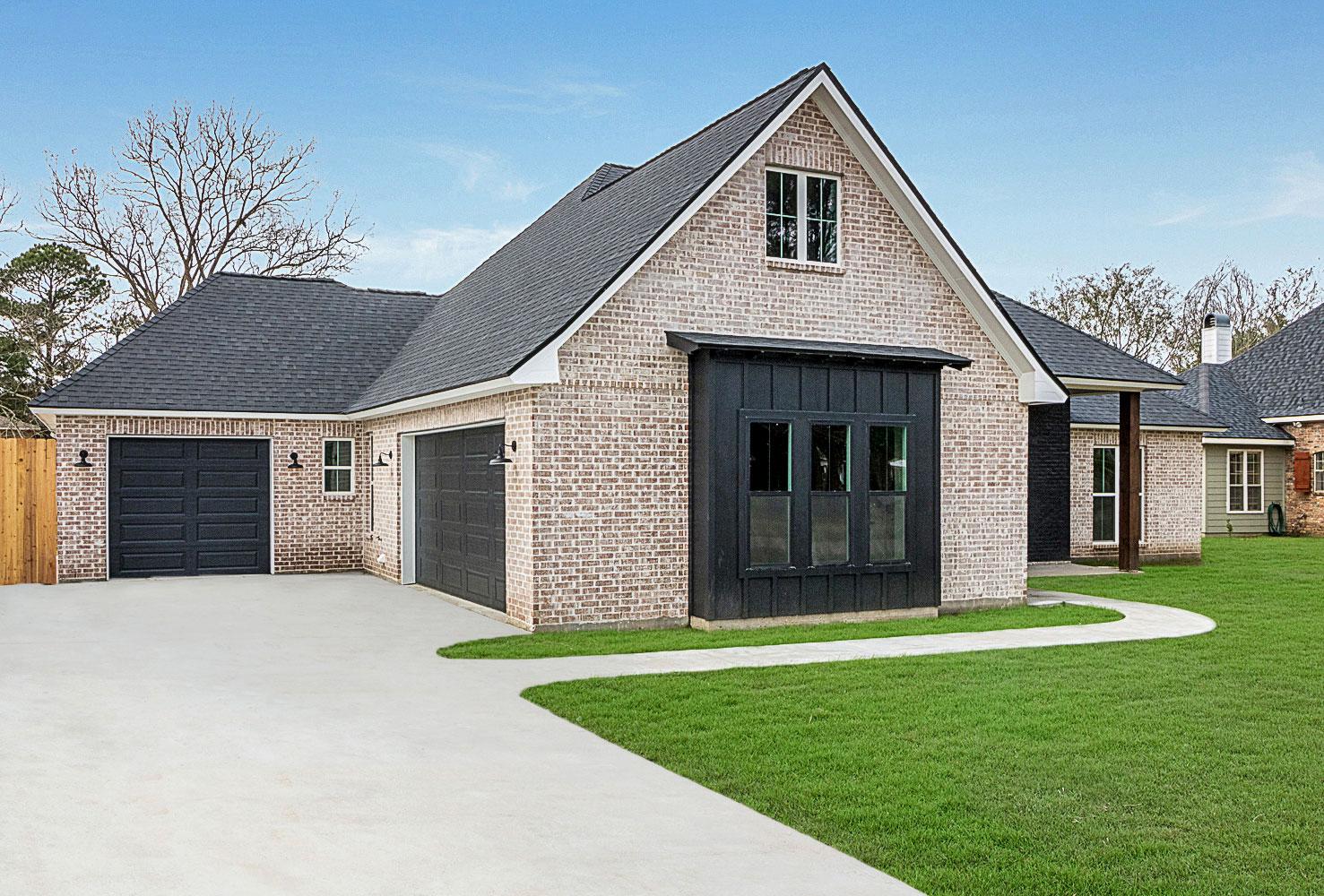 House plan exterior with light brick siding, gabled roof, two-car garage, and dark metal accents.