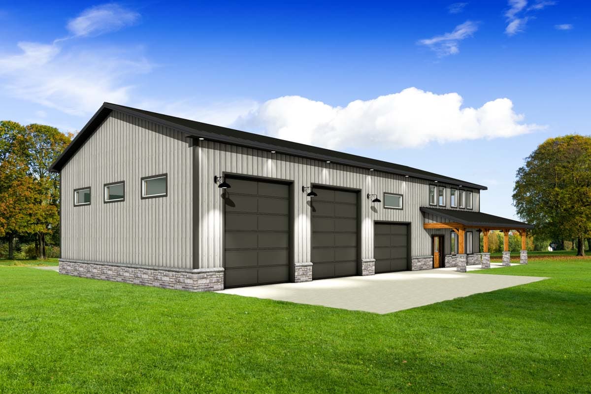 A modern metal building with three garage doors and a covered porch. The building sits on a grassy lawn with trees and a blue sky.