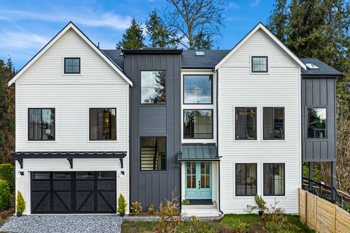 House plan exterior. Two-story Modern farmhouse with gables, a covered entry, and black-framed windows throughout.
