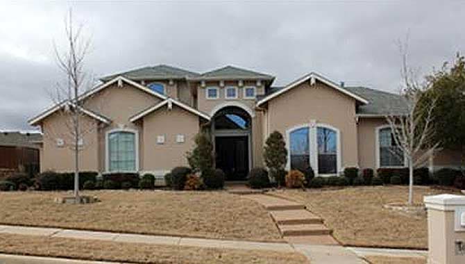 Two-story house plan exterior with stucco finish, arched entry, multiple gables, and arched windows.