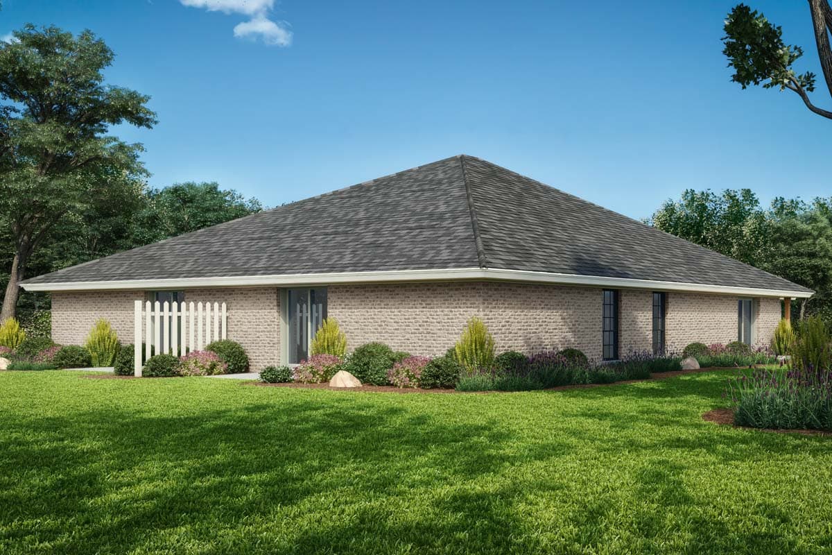 House plan exterior: Single-story brick home with a hip roof, side-entry garage, and a white picket fence.