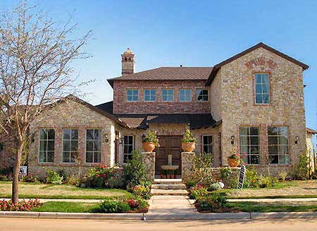 House plan exterior: Two-story stone and brick home with a prominent brick chimney, arched entryway, and multiple gables.
