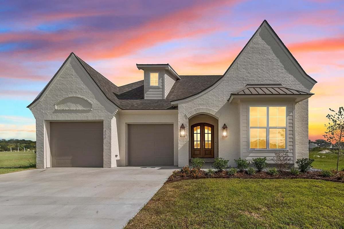 House plan exterior: White brick, two-car garage, arched entry with double doors, dormer, steep gables, and metal roof accents.