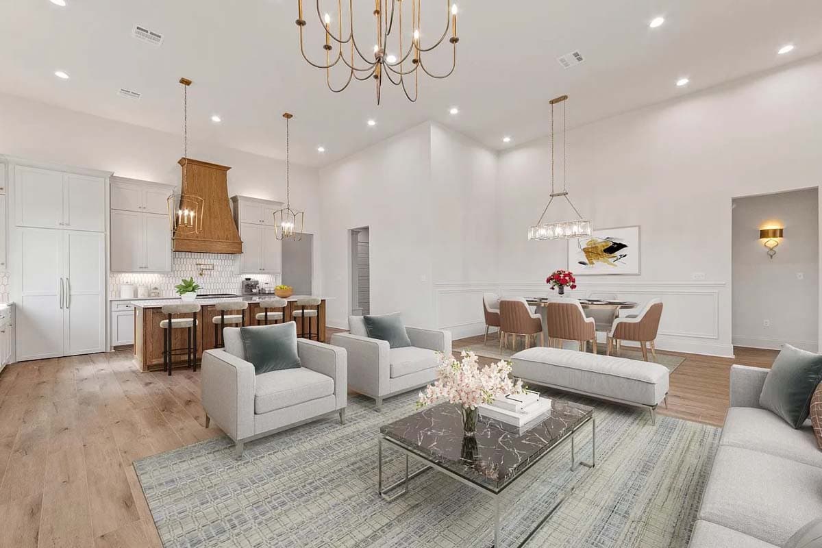 Open-concept living space with kitchen island, dining area, and seating area with fireplace. Vaulted ceiling.