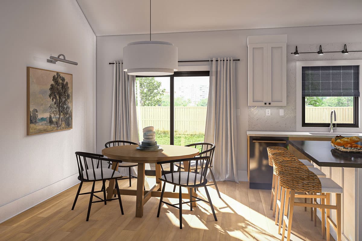 Interior view of dining area with round table, chairs, and adjacent kitchen island with bar stools.