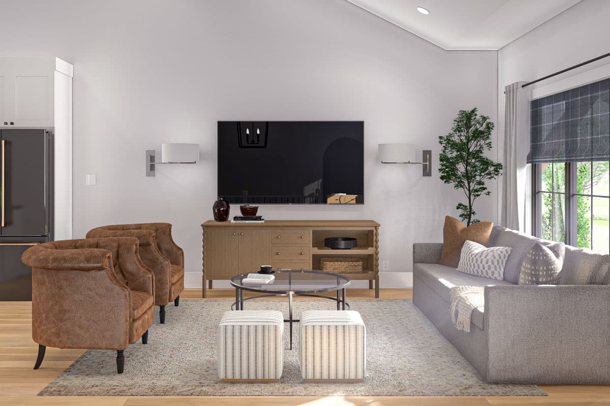 Living room with a gray sofa, two brown armchairs, entertainment console, coffee table, and wall-mounted TV.