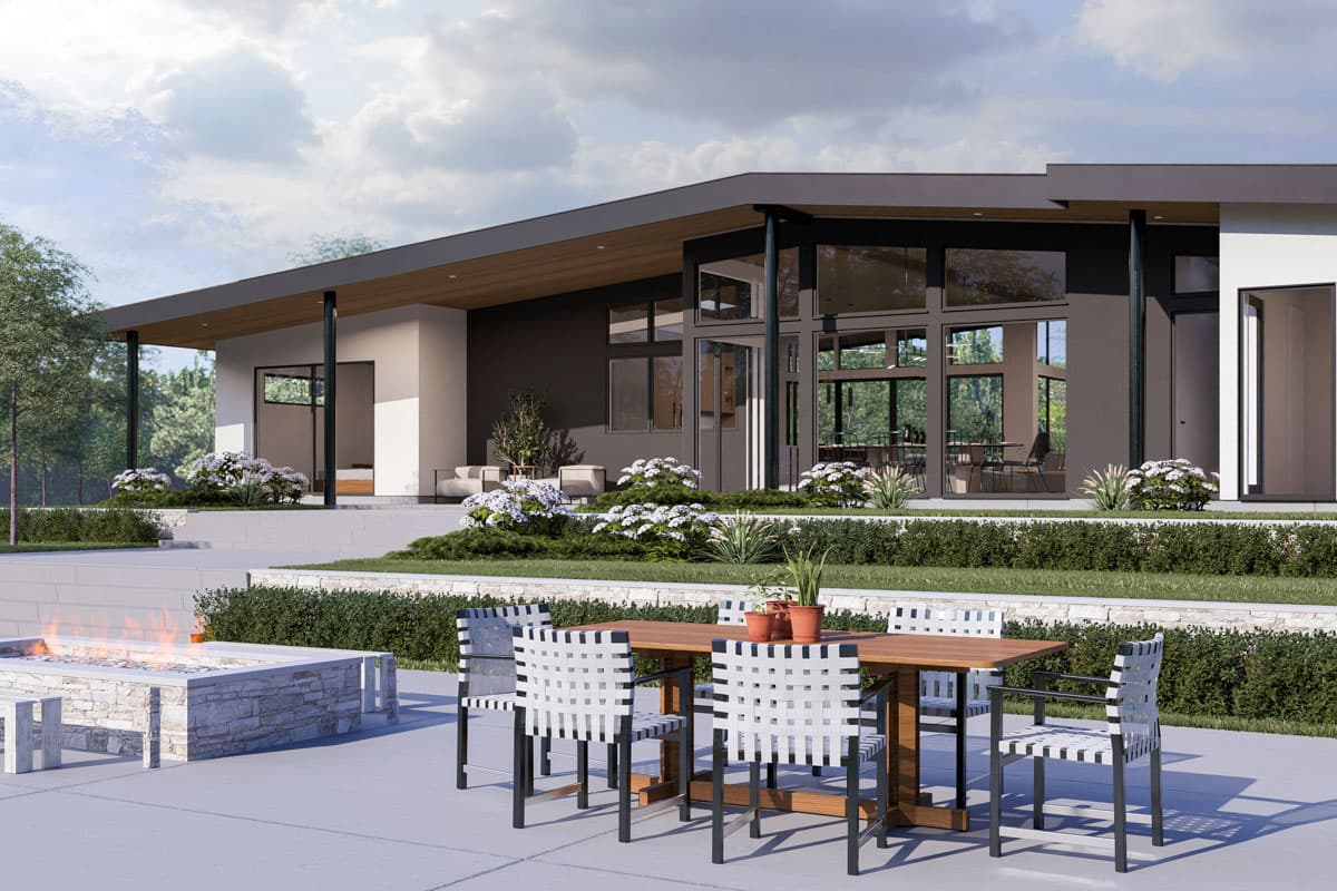 Modern house plan exterior with a low-pitched roof, large windows, and covered patio. Outdoor seating and fire pit visible.