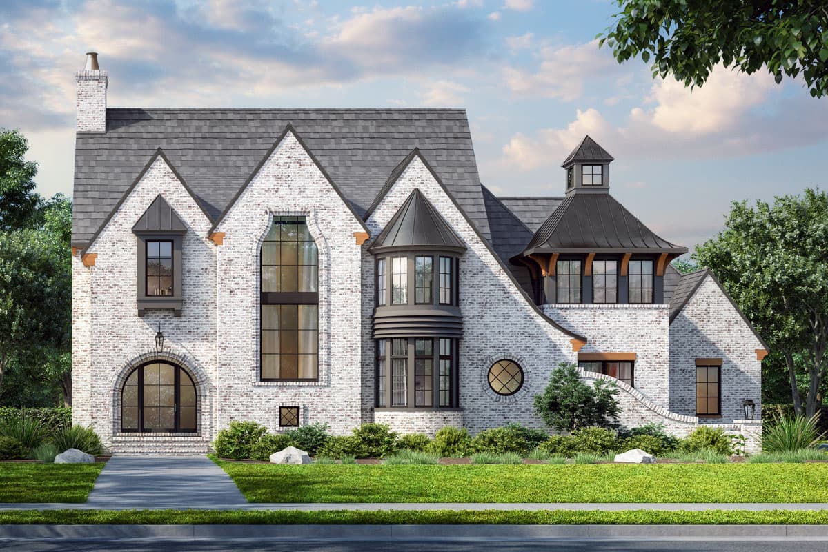 House plan exterior. Two-story English Tudor with gables, a turret, and brick facade. Features include arched entry and round window.