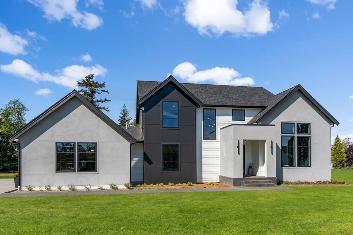 House plan exterior. Two-story modern house with gabled rooflines, contrasting dark siding, and a covered entry porch.