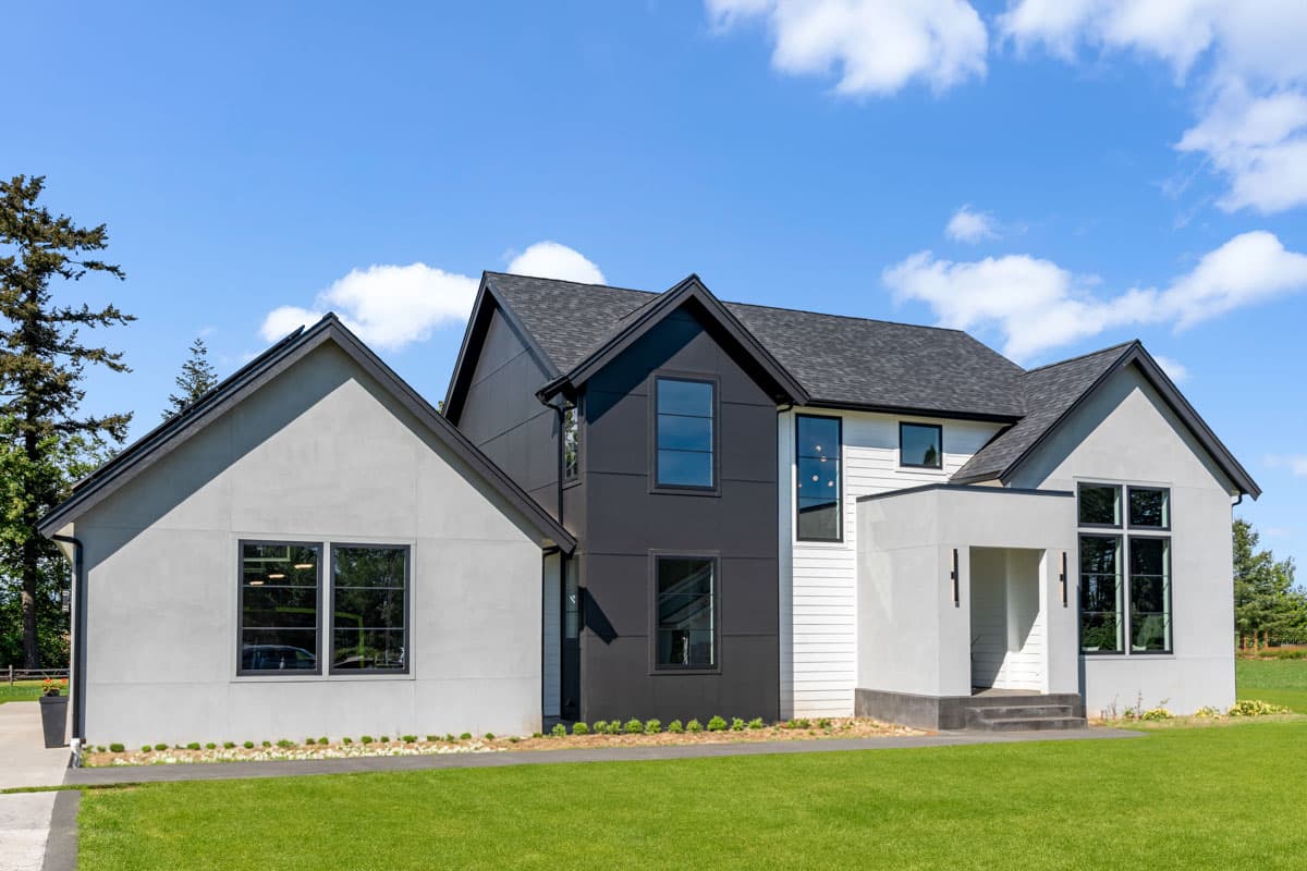 House plan exterior featuring a modern asymmetrical design with gabled roofs, contrasting stucco and siding, and prominent dark-framed windows.