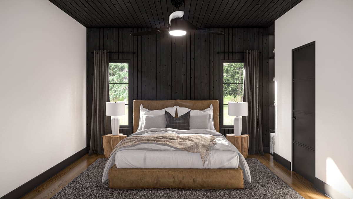 Bedroom interior with wood-paneled accent wall, tufted headboard bed, two windows, and dark wood ceiling fan.