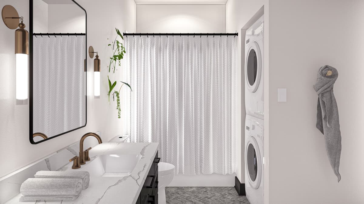 Bathroom with vanity, stacked washer/dryer, shower curtain, and wall sconces.